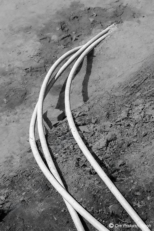 Exposed PVC pipes conveying water from DI pipe to FHTCs in a multi-village scheme under Jal Jeevan Mission in Seraikela-Kharsawan district, Jharkhand, India